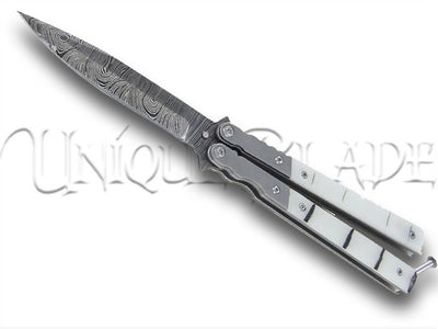 White Widow Balisong Damascus Steel Butterfly Knife: Elevate your skills with this distinctive drop point balisong, featuring a Damascus steel blade and a design that combines elegance and functionality.